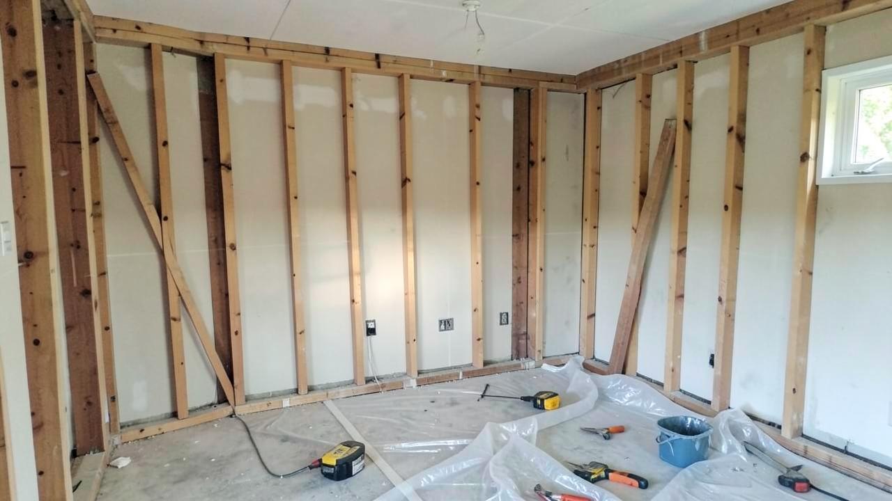 Half finished kitchen renovation with exposed framing and tools